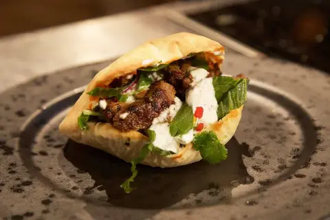 En saftig kebabrulle med kött, grönsaker och vit sås. Perfekt för dig som söker ett gott kebabkrydda recept.