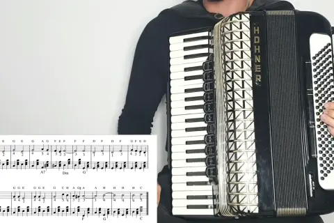 Osoba gra na akordeonie HOHNER, a przed nią leży nuta z zapisem melodii. To z pewnością materiał na przeboje na akordeon!