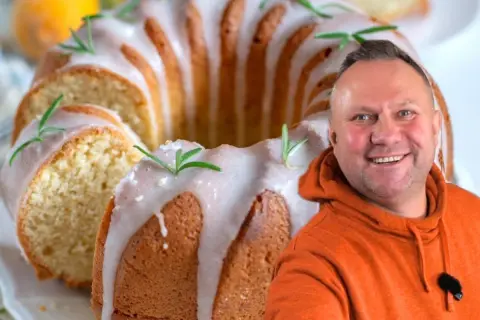Uśmiechnięty mężczyzna obok pysznej babki majonezowej z lukrem i rozmarynem.