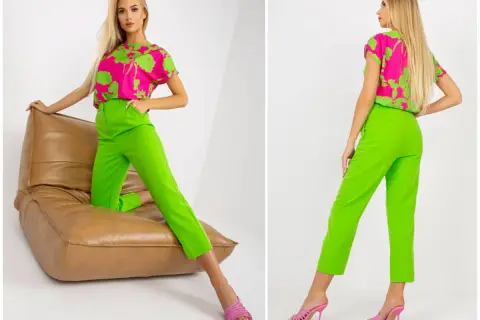 Jaka bluzka do zielonych spodni? Modelka prezentuje stylizację z fuksjową bluzką w zielone liście i neonowe, zielone spodnie.