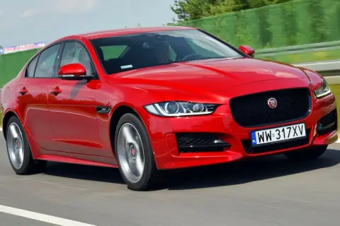 Czerwony Jaguar XE w ruchu na drodze.