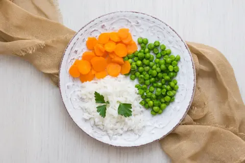Talerz z ryżem, marchewką i groszkiem. Idealne składniki na dietę lekkostrawną, proste i zdrowe.
