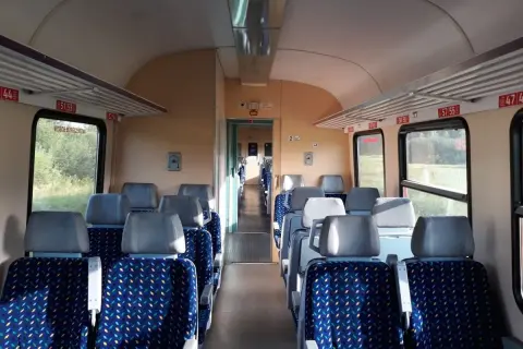 Puste siedzenia w wagonie kolejowym, gotowe na podróż pociągiem w Bieszczady.