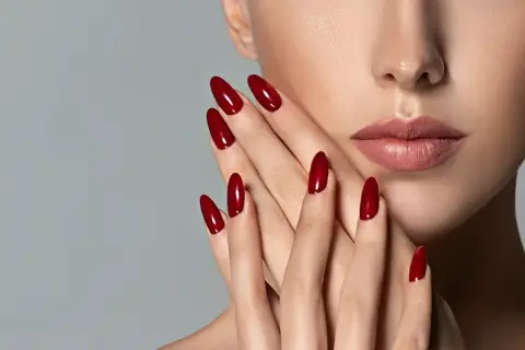 Mani eleganti con unghie a mandorla color rosso ciliegia, perfette per una durata semipermanente impeccabile.