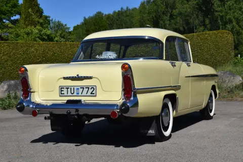 En ljusgul Vauxhall Victor från 1950-talet, en klassisk modell, står parkerad utomhus.
