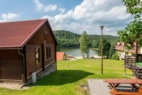 Drewniany domek nad jeziorem Śląsk, z placem zabaw i widokiem na las. Idealne miejsce na wypoczynek.