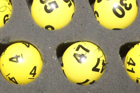 Żółte kulki z numerami do lotto, w tym 4, 41, 47, 30. Czy trójka w lotto plus jest płatna?