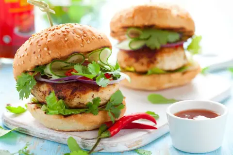 Deliciosa hamburguesa de pollo con pepino, cebolla morada, cilantro y chile rojo. ¡Un festín para los sentidos!