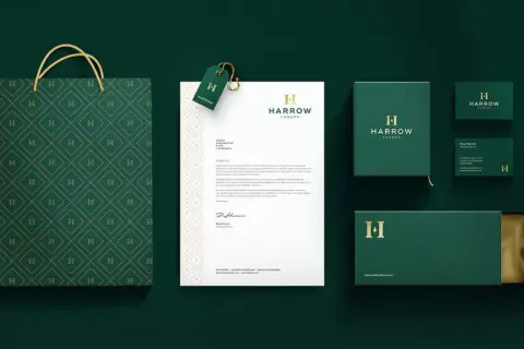 A sophisticated brand identity featuring a monogram logo with the letter "H" on a shopping bag, stationery, and packaging.