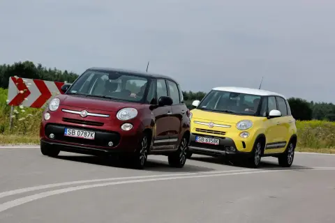 Dwa samochody Fiat 500L, jeden czerwony, drugi żółty, jadą po zakręcie drogi.