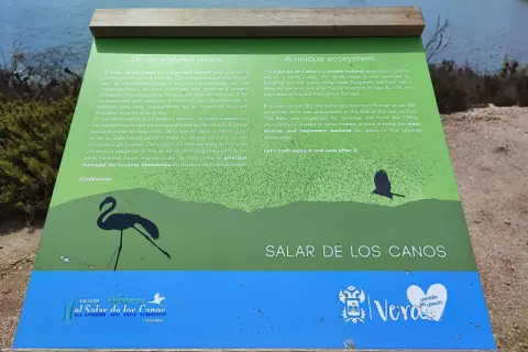 Un cartel informativo sobre el Salar de los Canos, un humedal costero y antiguo salinar, con siluetas de aves.
