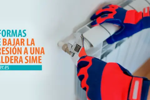Manos con guantes ajustando una llave inglesa en un radiador, para solucionar la presión de la caldera alta.