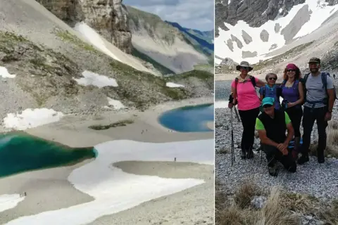 Gruppo di escursionisti al lago di Pilato, con le sue acque turchesi e i nevai circostanti.