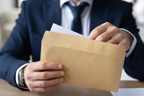 Mężczyzna w garniturze wkłada dokument do brązowej koperty. Czy odpowiedź na apelację doręcza się bezpośrednio pełnomocnikowi?