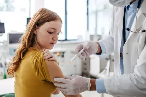 Dziewczynka otrzymuje szczepienie. To ważny krok w zapewnieniu jej zdrowia, podobnie jak fsme immun junior chroni przed kleszczowym zapaleniem mózgu.