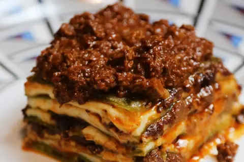 Una porzione di lasagne al ragù, stratificata con pasta, besciamella e un ricco ragù di carne.