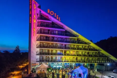 Hotel Diament Ustroń nocą, z neonami "SPA" i "HOTEL". Wiele pozytywnych **spa & wellness hotel diament ustroń opinie** potwierdza jego wyjątkowość.