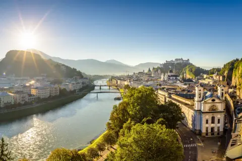 Sonnenaufgang über Salzburg. Die Salzach fließt durch die Stadt, im Hintergrund die Festung Hohensalzburg. Ein perfekter Morgen für smbs salzburg.
