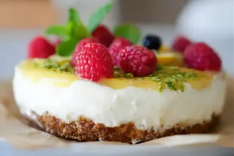 En läcker citron cheesecake med hallon och mynta.