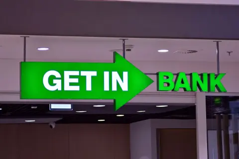 Zielona, podświetlana strzałka z napisem "GET IN" prowadzi do wejścia do banku.