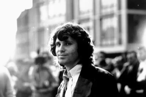 Jim Morrison, z burzą włosów i spojrzeniem wprost w obiektyw. Czy Jim Morrison miał dzieci? To pytanie pozostaje bez odpowiedzi, podobnie jak wiele innych tajemnic związanych z legendą rocka.