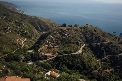Serpentinenstraßen schlängeln sich durch die Hügel bei Taormina. Entdecken Sie versteckte Orte und genießen Sie die Aussicht auf das Meer – Taormina Geheimtipps für Abenteurer.