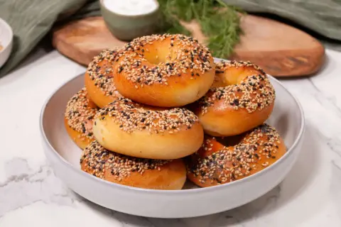 Ein Haufen frisch gebackener Bagels, bestreut mit Sesam und Mohn, perfekt für ein proteinreiches Bagel-Rezept.