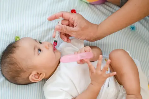 Dziecko otrzymuje suplementację witaminy D z pipetki.