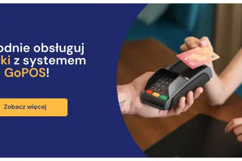 Dłoń zbliża kartę zbliżeniową do terminala płatniczego.
