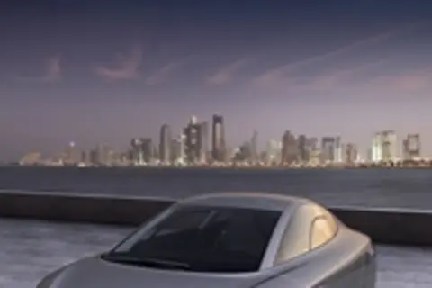 Elegancki VW XL1 na tle nocnej panoramy miasta.