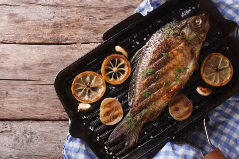 Gegrillter Karpfen mit Zitrone und Rosmarin auf einer Grillpfanne. Ein köstliches Beispiel für Karpfen Gerichte.