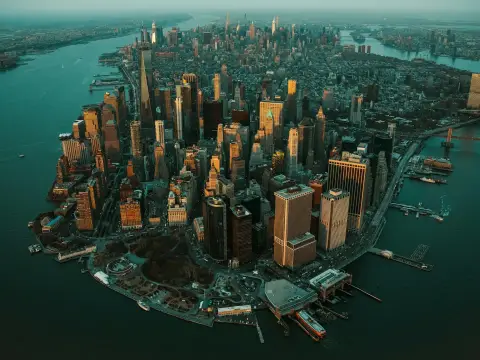 Zachód słońca nad Manhattanem, ta scena ukazuje panoramę drapaczy chmur i rzeki.