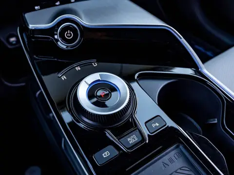 Pokrętło wyboru biegów w nowoczesnym samochodzie z napędem elektrycznym. Widoczny przycisk EV i oznaczenia R, N, D. Skrzynia biegów automat ułatwia jazdę.