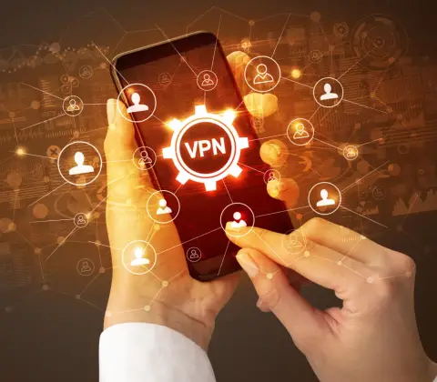 Dłonie trzymające smartfon z ikoną VPN i siecią połączeń użytkowników.