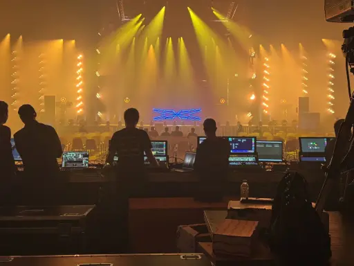 Tecnici al lavoro con console luci e schermi, pronti per un grande evento al MIR Rimini.