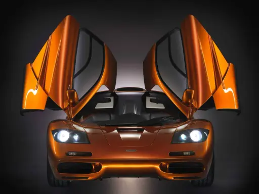 Orange McLaren F1 mit geöffneten Flügeltüren. Ein Traumauto, dessen McLaren F1 Preis unbezahlbar ist.