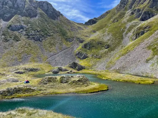 Un accampamento solitario ai laghetti di Ponteranica, tra montagne verdi e acque cristalline.