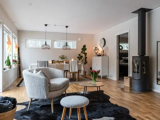 Mysigt vardagsrum inspiration med en fluffig fåtölj, kamin och matplats. Perfekt för kalla kvällar.