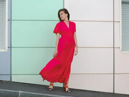 Elegancka kobieta w czerwonej sukience maxi, idealna odpowiedź na pytanie "w co się ubrać na wesele po 40".