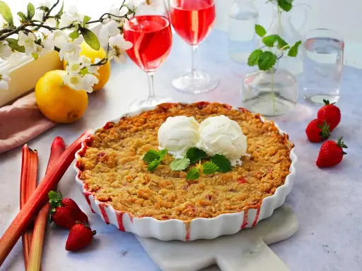 En härlig jordgubbspaj med smuldeg, serverad med vaniljglass och mynta. Perfekt för ett somrigt jordgubbspaj recept.