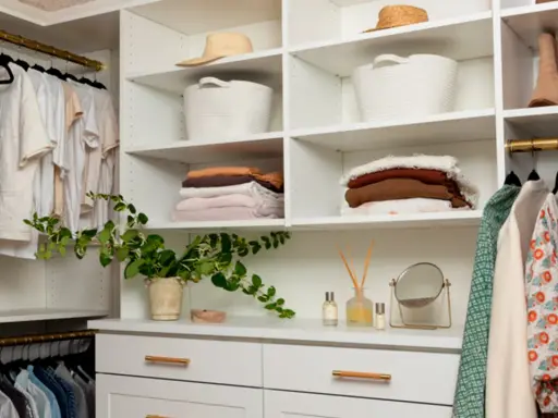 Un vestidor organizado con ropa colgada y doblada, cestas y sombreros. Ideas para como diseñar un vestidor funcional y estético.