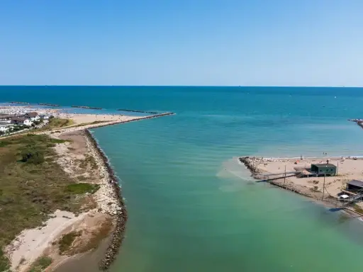 Lido di Savio, Milano Marittima: un'insenatura con moli frangiflutti e stabilimenti balneari affacciati sul mare Adriatico.