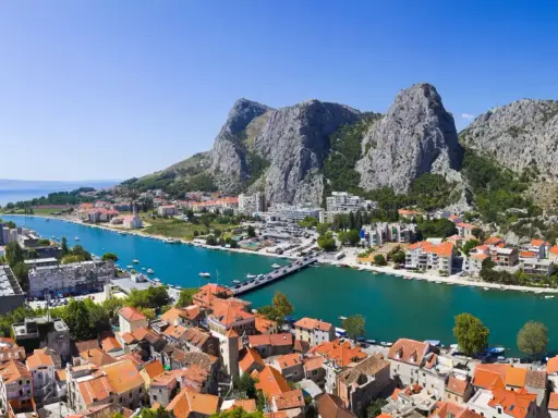 Widok na miasto Omis w Chorwacji z rzeką Cetina i górami w tle.