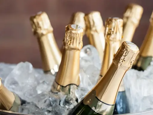 Mehrere Flaschen Prosecco kühlen in einem Eisbad. Perfekt für eine Feier, was ist Prosecco? Ein prickelnder Genuss!