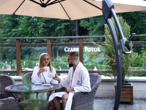 Para młoda w szlafrokach pije kawę na tarasie. Idealne miejsce na podróż poślubną w Polsce.