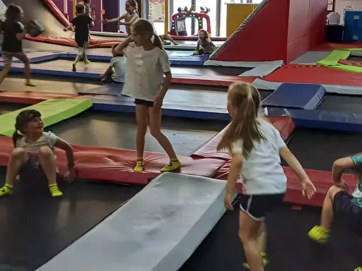 Dzieci skaczą na trampolinach w parku rozrywki. To świetne gorzów wielkopolski atrakcje dla dzieci, pełne radości i ruchu.