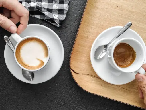 Zwei Espresso auf italienisch, einer mit Milchschaum, der andere schwarz, bereit zum Genießen.
