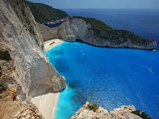 Widok na Navagio, słynną zatokę wraku w Grecji, z turkusową wodą i białymi klifami.