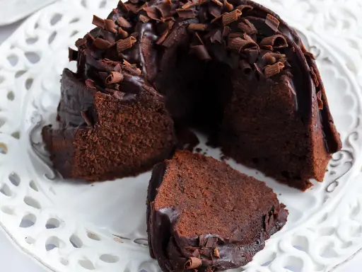 Pyszna babka z mascarpone i kakao, polana czekoladą i posypana wiórkami. Idealna na deser.