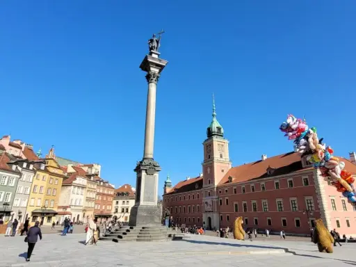 Kolumna Zygmunta i Zamek Królewski na placu w sercu starego miasta Warszawa. Balony unoszą się na błękitnym niebie.